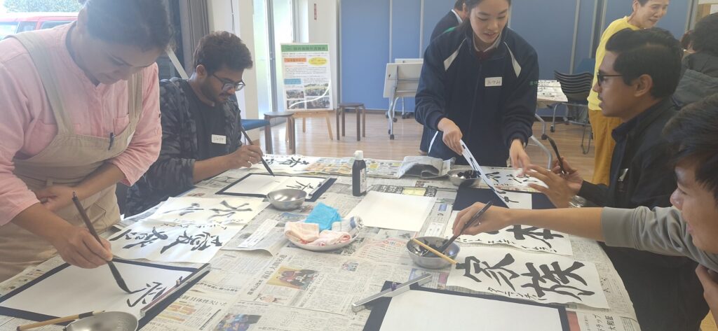 Participants writing with brushes at a calligraphy session