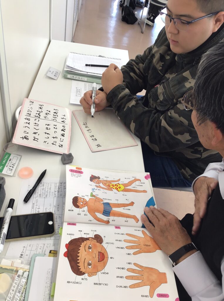 絵カードを見ながら日本語のことばを学ぶ学習者