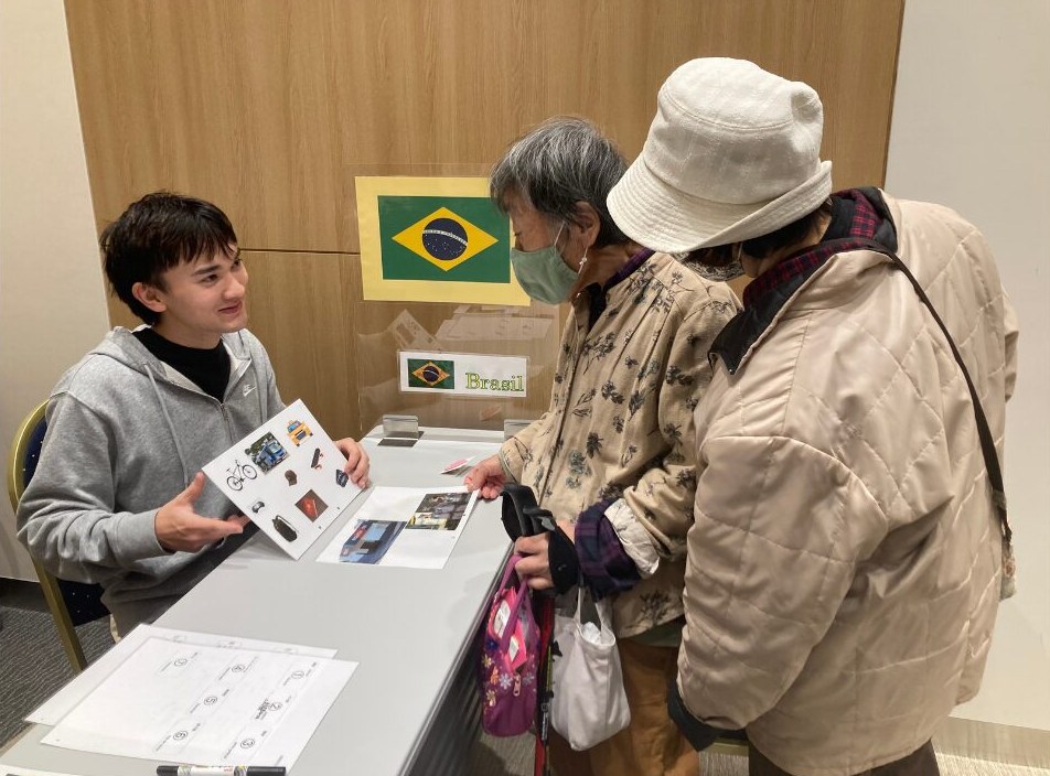 ブラジルのブースで写真を見せながら紹介する様子