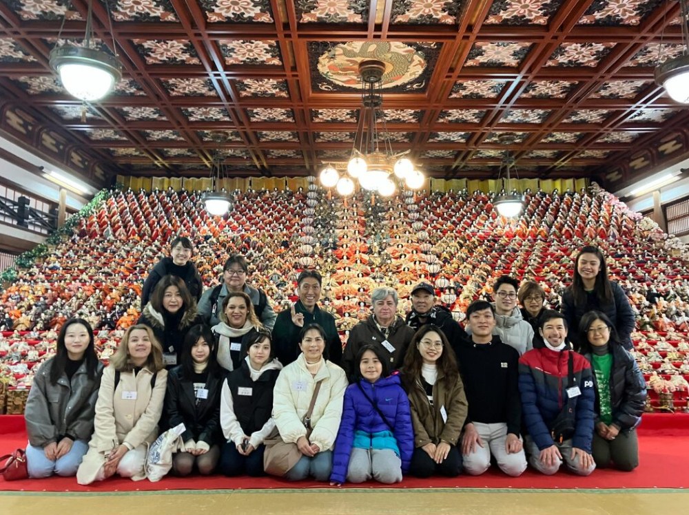 ひな人形の前で交流会に参加したみなさんの集合写真